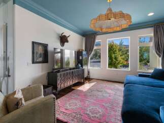 Experience luxurious living in this stunning room featuring a vibrant blue ceiling and a large, plush sectional sofa perfect for relaxation.