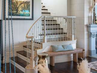 This elegant home features a grand staircase with a curved banister and ornate railings, perfect for making a statement.