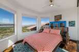Experience breathtaking panoramic views from this stunning bedroom, featuring large windows that showcase the picturesque landscape and distant city lights.