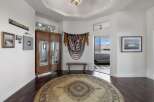 Step into this inviting entryway featuring a large round rug and a beautiful wooden armoire with mirrored doors.