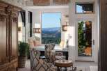 Experience breathtaking panoramic views from this stunning living space, featuring a cozy window seat perfect for enjoying the scenery.