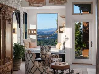Experience breathtaking panoramic views from this stunning living space, featuring a cozy window seat perfect for enjoying the scenery.