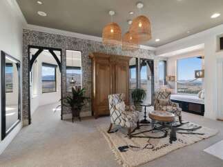 Experience breathtaking panoramic views from this stunning bedroom, featuring a cozy window seat perfect for enjoying the scenery.