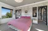 Experience luxury in this stunning bedroom featuring a plush pink duvet and a decorative white headboard.