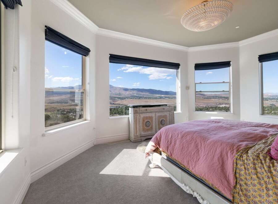 Experience breathtaking panoramic views from this stunning bedroom, featuring expansive windows that showcase the majestic mountain landscape.