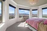 Experience breathtaking panoramic views from this stunning bedroom, featuring expansive windows that showcase the majestic mountain landscape.