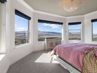Experience breathtaking panoramic views from this stunning bedroom, featuring expansive windows that showcase the majestic mountain landscape.