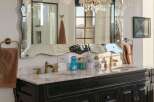 Indulge in luxury with this elegant bathroom vanity featuring a marble countertop and a decorative mirrored backsplash.