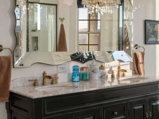 Indulge in luxury with this elegant bathroom vanity featuring a marble countertop and a decorative mirrored backsplash.