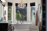 Indulge in luxury in this stunning bathroom featuring a freestanding soaking tub with a breathtaking mountain view.
