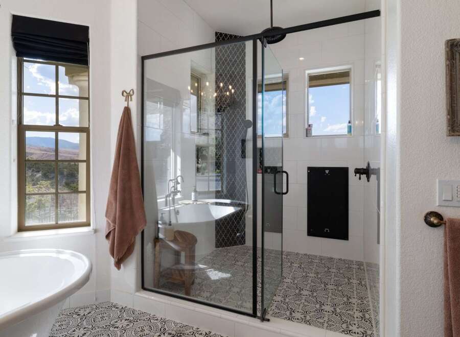 Indulge in luxury with this stunning bathroom featuring a freestanding soaking tub and a spacious glass-enclosed shower.