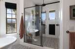 Indulge in luxury with this stunning bathroom featuring a freestanding soaking tub and a spacious glass-enclosed shower.