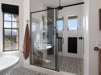 Indulge in luxury with this stunning bathroom featuring a freestanding soaking tub and a spacious glass-enclosed shower.