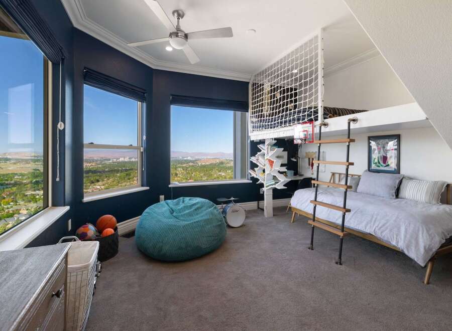 Experience breathtaking panoramic views from this stunning bedroom, featuring expansive windows that showcase a vibrant cityscape and rolling hills.