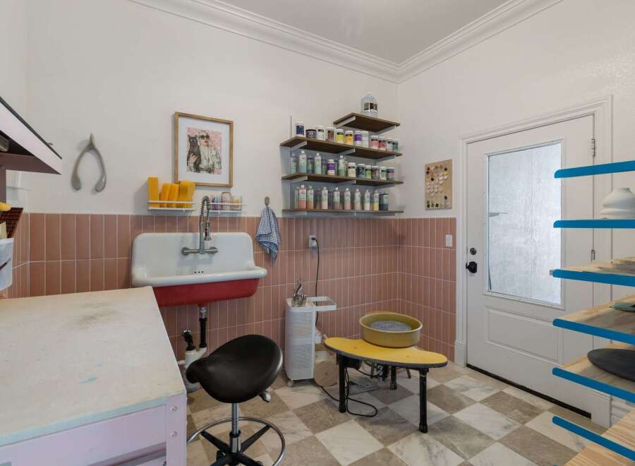 Discover your creative sanctuary in this well-equipped art studio, featuring a deep utility sink and ample storage for all your supplies.