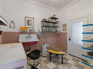 Discover your creative sanctuary in this well-equipped art studio, featuring a deep utility sink and ample storage for all your supplies.