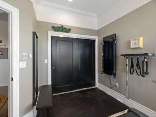 This home gym features a black double door leading to a workout space with a dark floor.