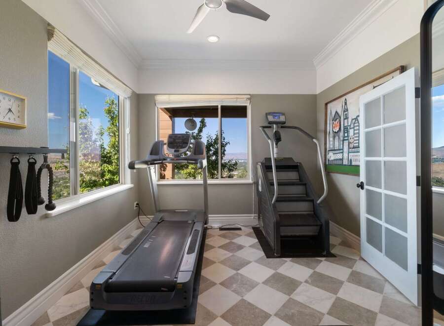 Elevate your fitness routine in this dedicated home gym, featuring a treadmill and stair climber for a comprehensive workout.