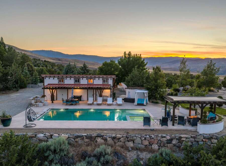 Experience luxurious outdoor living with this stunning property featuring a sparkling swimming pool and an inviting hot tub, perfect for relaxation.