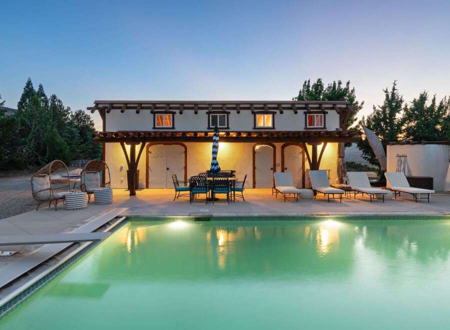 Experience luxury outdoor living with this stunning property featuring a sparkling swimming pool and a covered patio perfect for al fresco dining.