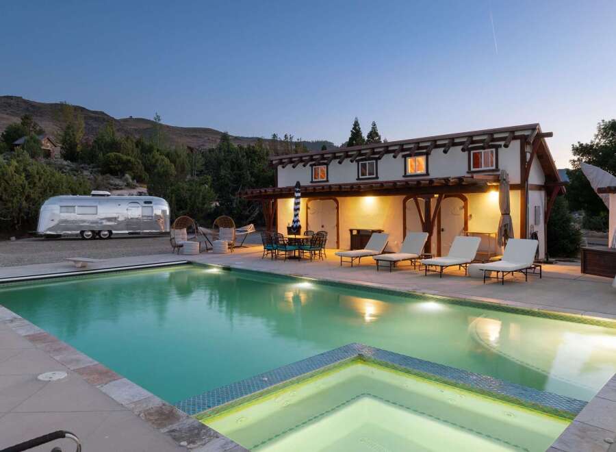 Experience luxury glamping with this unique Airstream trailer and stunning pool area, perfect for a memorable getaway.