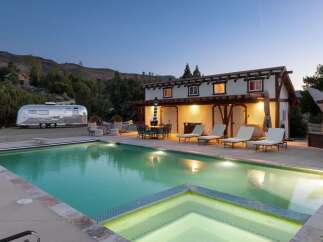 Experience luxury glamping with this unique Airstream trailer and stunning pool area, perfect for a memorable getaway.