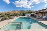 Experience ultimate relaxation in this stunning backyard oasis featuring a sparkling swimming pool and integrated spa, perfect for unwinding under the vast blue sky.