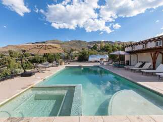 Experience ultimate relaxation in this stunning backyard oasis featuring a sparkling swimming pool and integrated spa, perfect for unwinding under the vast blue sky.