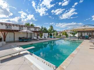 Experience luxurious outdoor living with this stunning backyard oasis, featuring a sparkling swimming pool and a relaxing spa.