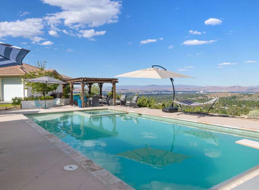 Enjoy breathtaking panoramic views from this stunning backyard oasis, complete with a sparkling swimming pool and integrated spa.
