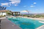 Enjoy breathtaking panoramic views from this stunning backyard oasis, complete with a sparkling swimming pool and integrated spa.