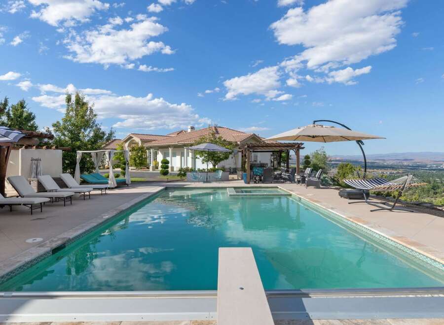 Experience luxury outdoor living with this stunning backyard oasis, featuring a sparkling swimming pool and relaxing hot tub.