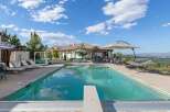 Experience luxury outdoor living with this stunning backyard oasis, featuring a sparkling swimming pool and relaxing hot tub.