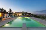 Experience luxury living with this stunning property featuring a large, illuminated swimming pool and a relaxing spa area.