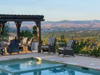 Enjoy breathtaking panoramic views of the city and mountains from this stunning outdoor living space.