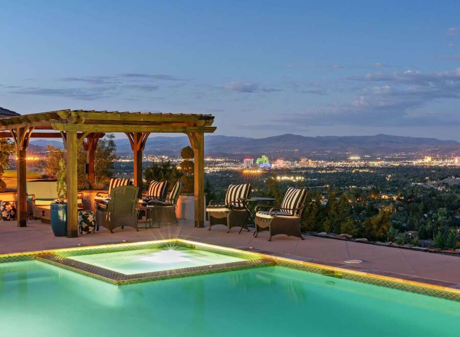 Experience luxury living with this stunning property featuring an infinity pool and spa overlooking a vibrant city skyline.
