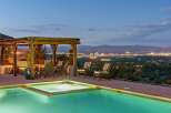 Experience luxury living with this stunning property featuring an infinity pool and spa overlooking a vibrant city skyline.