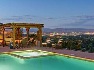 Experience luxury living with this stunning property featuring an infinity pool and spa overlooking a vibrant city skyline.