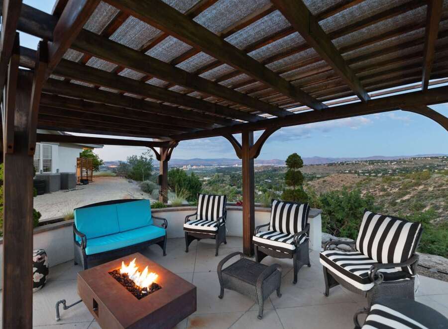 Enjoy breathtaking panoramic views from this stunning outdoor living space, complete with a cozy fire pit and comfortable seating.