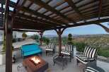 Enjoy breathtaking panoramic views from this stunning outdoor living space, complete with a cozy fire pit and comfortable seating.