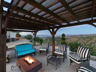 Enjoy breathtaking panoramic views from this stunning outdoor living space, complete with a cozy fire pit and comfortable seating.