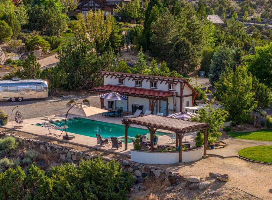 Experience luxury outdoor living with this stunning property featuring a sparkling swimming pool and a covered patio perfect for entertaining.