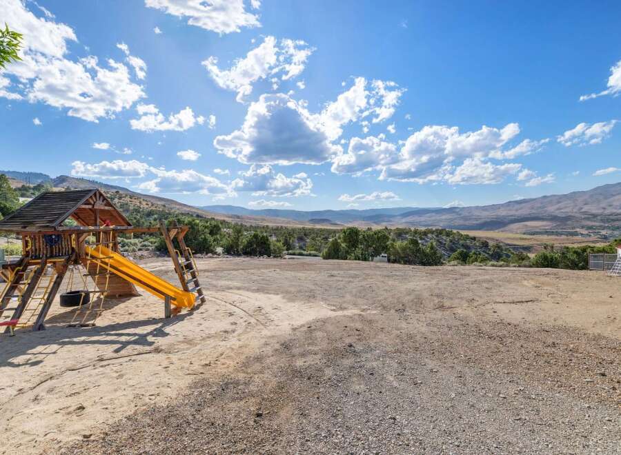 Discover your dream home with this stunning property featuring a spacious wooden playset, perfect for family fun.