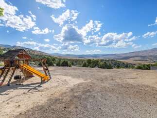 Discover your dream home with this stunning property featuring a spacious wooden playset, perfect for family fun.