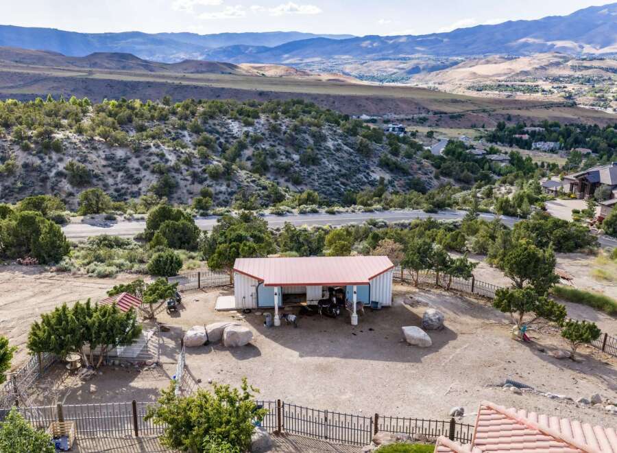 Discover this unique property featuring a charming barn with a red roof, perfect for housing animals or as a versatile workshop space.