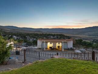 Experience the tranquility of this unique property featuring a modern barn structure with ample space for animals, set against a breathtaking mountain vista.