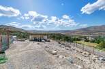 Discover this unique property featuring a spacious open-air shelter perfect for animals, complemented by a fenced enclosure and a scenic view of the surrounding valley.