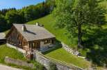 Nestled on a lush green hillside, this charming wooden chalet offers a serene mountain retreat.