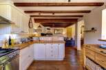 Experience rustic charm in this beautifully appointed kitchen, featuring exposed wooden beams and a cozy, country-style aesthetic.