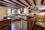 This charming kitchen boasts rustic wooden beams and a farmhouse sink, creating a warm and inviting atmosphere.